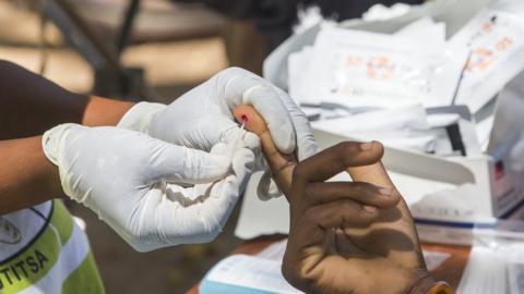 Person doing a finger-prick test for malaria
