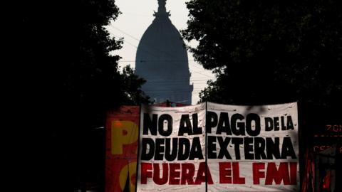 Demonstrators hold a banner that reads "no to foreign debt payment, IMF out"