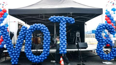 A volunteer sets up a balloon display during a get out the vote rally for Democratic senate candidates Jon Ossoff and Raphael Warnick