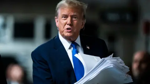 Donald Trump holding documents