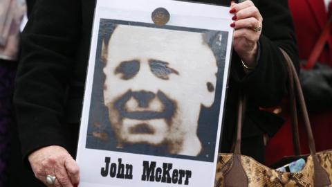 One of John McKerr's daughters holding a photograph of her father