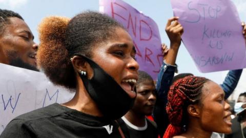 Demonstrators hold banners and shout slogans during a protest against alleged police brutality, in Lagos, Nigeria October 12, 2020.