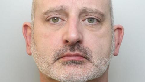 Police mugshot of Lee Smith, who has shaved grey hair and grey stubble.
