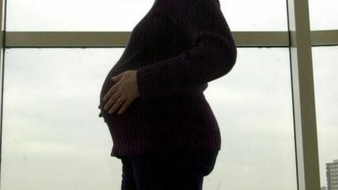 pregnant woman in front of window