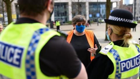 Police speak to NHS worker Karen Reissmann after breaking up a protest in Manchester