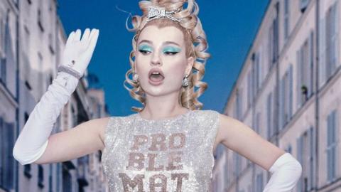 Kim Petras promotional photo, showing the singer in a sequinned top emblazoned with the word "Problematique"
