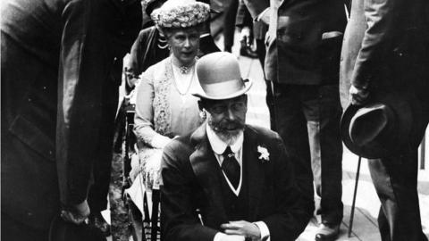 Black and white photo of King George V and Queen Mary riding a miniature train