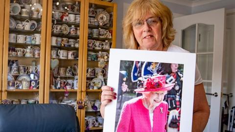 Royal enthusiast Sheila Clark stands with a portrait of Queen Elizabeth II