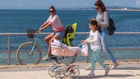 A woman walk with her daughter in Palma, Balearics, Spain