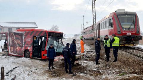 Police officers at the scene where a train ploughed through a bus in southern Serbia, 21 December 2018