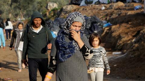 Migrants make their way at a makeshift camp next to the Moria camp, on the island of Lesbos, Greece, November 15, 2019