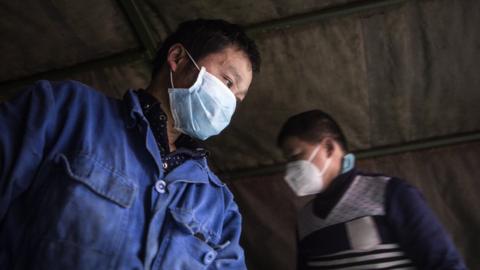 staff carry vegetables from a truck to a hospital in wuhan