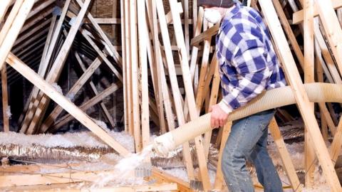 Worker spraying insulation foam