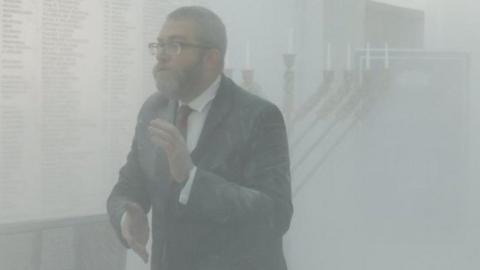 Grzegorz Braun, far-right Polish lawmaker from Confederation party, looks on after using a fire extinguisher to put out Hanukkah candles at the parliament in Warsaw, Poland December 12, 2023