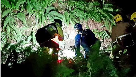 Coastguard rescue woman from ravine with ropes