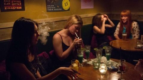 Girls smoke in a bar in central Moscow on May 30, 2014. Tough new anti-smoking legislation that comes into force on June 1