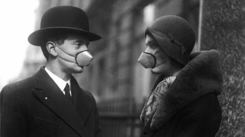 Two people wearing surgical masks