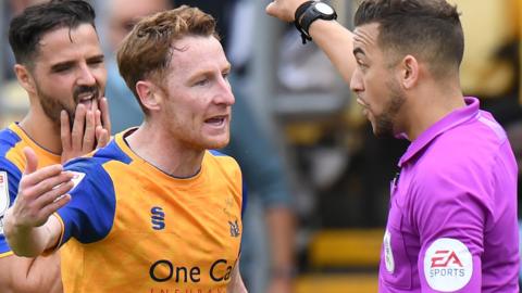 Mansfield's Steven Quinn remonstrates with referee Paul Howard