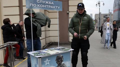 A man holds promotional materials of the Russian Defence Ministry, campaigning to sign up for contract service on April 9, 2023 in Moscow, Russia