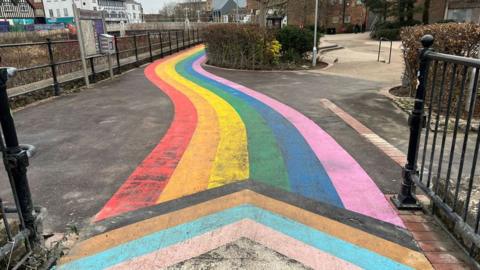 Rainbow pathway with concrete peeking through