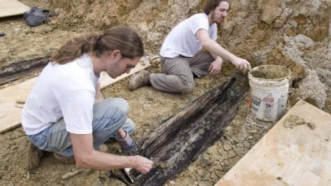 researchers unearthing coffins