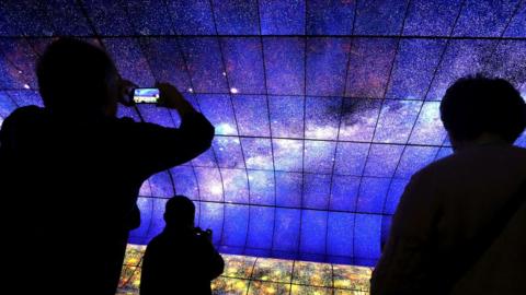 The LG screen wall is photographed by a smartphone user