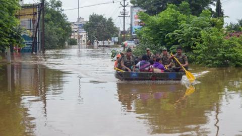 Indian Army personnel rescue people stranded in flood waters after heavy rains on the outskirts of Sangli in Maharashtra state.