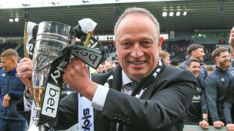 Derby owner David Clowes hold the promotion trophy