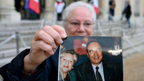 This woman called Edith carried a photo of herself with the former president as she paid her respects at the Élysée