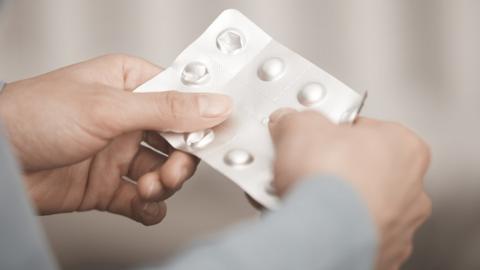 Woman holding packet of pills