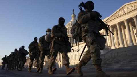 Soldiers walk in a line outside Capitol