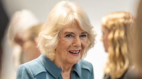 A close up of Queen Camilla smiles during her visit to London's Royal Free Hospital