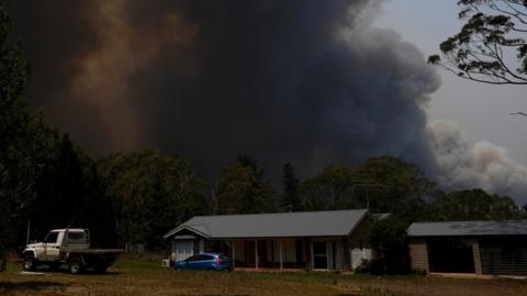 Smoke from the Grose Valley Fire rises over a home in Bilpin, New South Wales