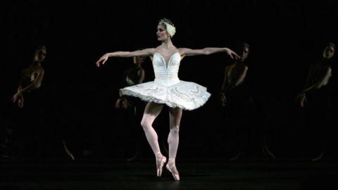 A dancer performing in Swan Lake at the Royal Opera House