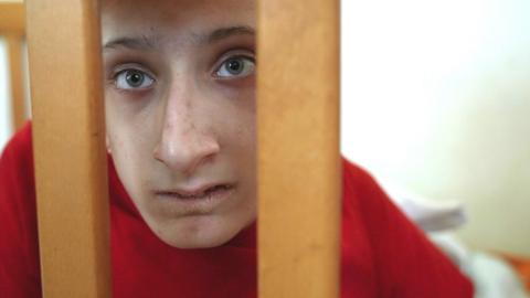 Disabled boy in a cot