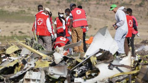 Forensics investigators and recovery teams collect personal effects and other materials from the crash site of Ethiopian Airlines jet