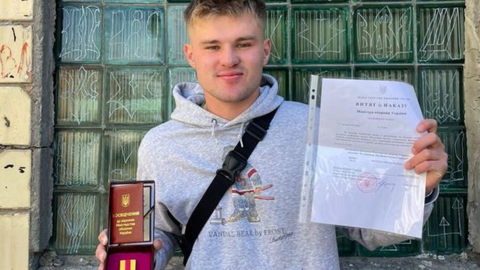 Fynn holding his award and medal