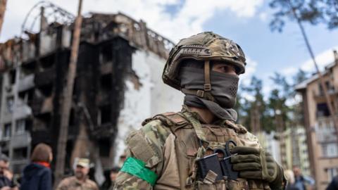 A Ukrainian army soldier stands guard in Irpin