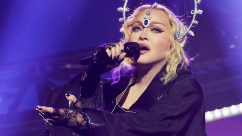Madonna sings into a microphone while performing during the opening night of The Celebration Tour at The O2 Arena on October 14, 2023 in London, England