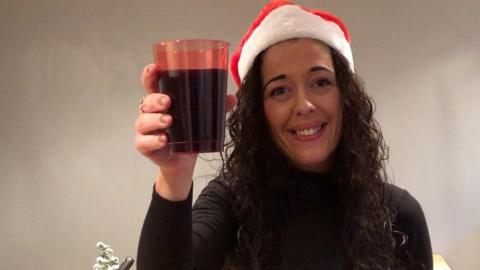 Sonia Cheetham holding a cup of mulled wine