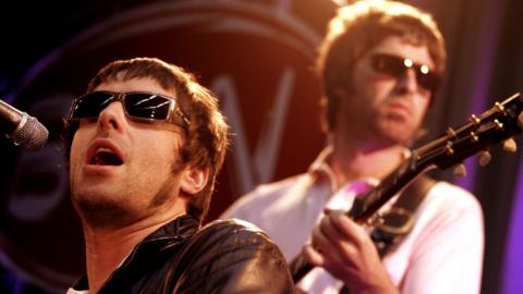 Liam and Noel Gallagher performing live onstage