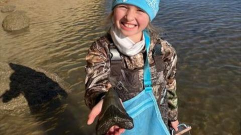 Molly poses with her megalodon tooth