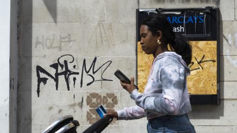 Woman walking looking at phone