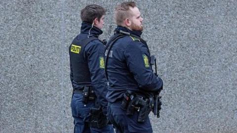 Armed police patrol outside the court