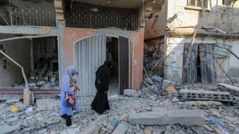 People inspect damage and remove items from their homes following Israeli airstrikes on April 07, 2024 in Khan Yunis, Gaza