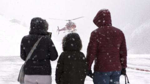 A family with their baggage await a helicopter for a flight by airlift to Täsch in Zermatt, Switzerland, 21 January 2018