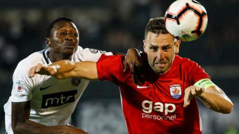 George Horan of (R) Connah's Quay competes for ball against Umar Sadiq L) of Partizan