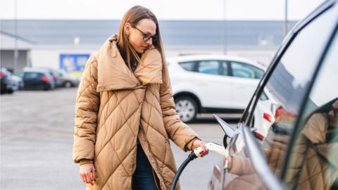 Woman charging an electric car