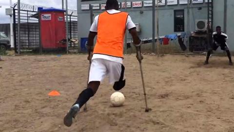 Emmanuel Ibeawuchi on crutches takes a penalty kick