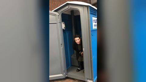 Louisa Marnoch in portable toilet